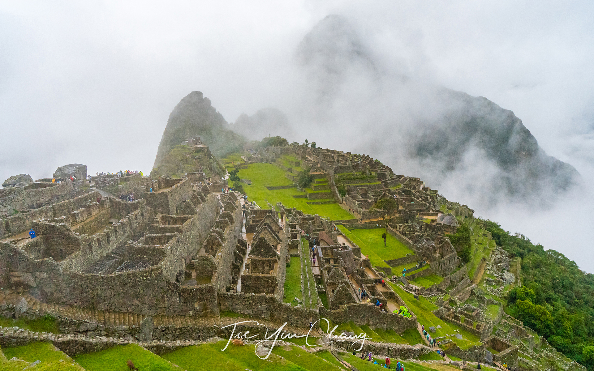 The famous shot of Machu Picchu, view of the main square from the city gate. Huayna Picchu is hidden behind the cloud